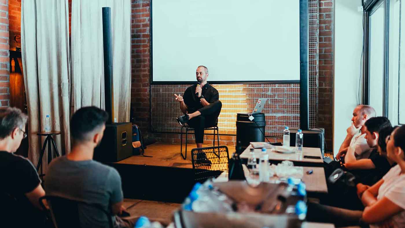 A man sitting on the floor in front of a projector screen.