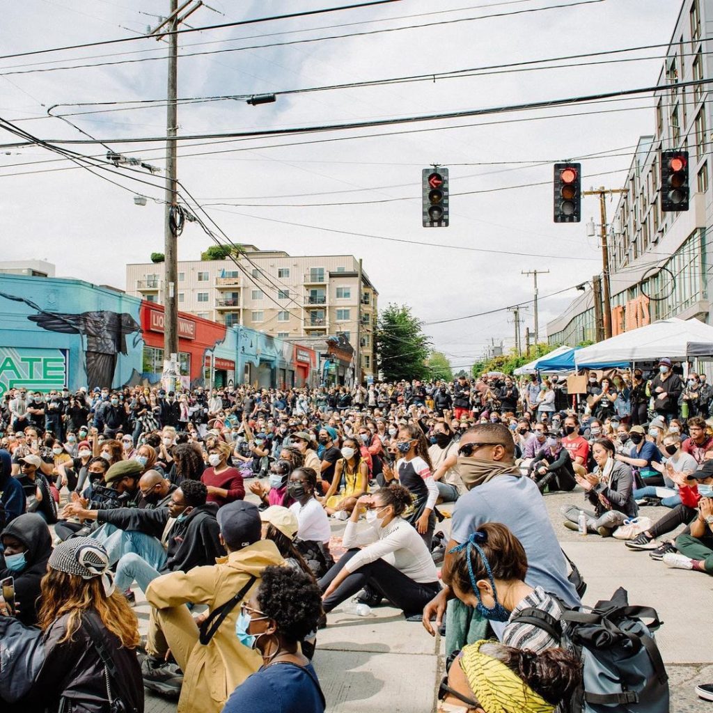 A crowd of people sitting on the side walk